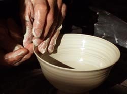 two hands throwing a bowl
